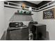 Functional laundry room with black front load washer and dryer and modern decor at 7207 Gladstone Cir, Stonecrest, GA 30038