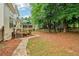 Lush backyard showcasing a stone pathway, well-maintained lawn, and mature trees, enhancing outdoor living at 1006 Amberton Ln, Powder Springs, GA 30127