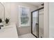 Bathroom featuring a glass shower door, black faucet, and large window at 1006 Amberton Ln, Powder Springs, GA 30127