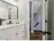 Bright bathroom showcasing modern vanity, faucet, mirror, and an open doorway to the staircase at 1006 Amberton Ln, Powder Springs, GA 30127