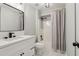 Bathroom with white vanity, black hardware and fixtures and a shower-tub combination with curtain at 1006 Amberton Ln, Powder Springs, GA 30127