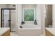 This bathroom features a large tub, a separate shower, and bright windows at 1006 Amberton Ln, Powder Springs, GA 30127