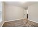 Bright carpeted bedroom has neutral walls and baseboards with a view to the staircase, creating a fresh ambiance at 1006 Amberton Ln, Powder Springs, GA 30127