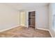 Bedroom with neutral walls, plush carpet, an open closet with shelves and a window at 1006 Amberton Ln, Powder Springs, GA 30127