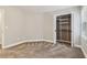 Neutral carpeted bedroom with bi-fold closet door and shelves offers ample storage and a bright, airy feel at 1006 Amberton Ln, Powder Springs, GA 30127