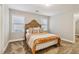 Bedroom with neutral walls, plush carpet, a bed with an orange blanket and two windows at 1006 Amberton Ln, Powder Springs, GA 30127