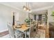 Well-lit dining room with wood floors, decorative rug, and view into office area at 1006 Amberton Ln, Powder Springs, GA 30127