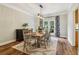 Bright dining room featuring wainscoting, a modern light fixture, and a beautiful wood floor at 1006 Amberton Ln, Powder Springs, GA 30127
