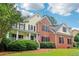Beautiful home with mature trees, lush lawn, a brick and siding facade, and a covered porch at 1006 Amberton Ln, Powder Springs, GA 30127
