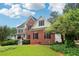 Charming brick home with a lush green lawn, mature trees, and an inviting front porch at 1006 Amberton Ln, Powder Springs, GA 30127