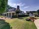 Charming two-story home with a landscaped yard, covered porch, and community pool in the background at 1006 Amberton Ln, Powder Springs, GA 30127