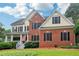 Charming two-story home featuring a brick facade, yellow siding, black shutters, and a well-manicured lawn at 1006 Amberton Ln, Powder Springs, GA 30127