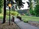 A scenic view of a wooden bridge leading to a gazebo amidst a lush green landscape at 1006 Amberton Ln, Powder Springs, GA 30127