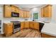 Well-lit kitchen boasts stainless steel appliances, wood cabinetry, and a sleek countertop at 1006 Amberton Ln, Powder Springs, GA 30127