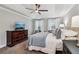 This main bedroom features a tray ceiling, carpeted floors, a dresser, and a flatscreen TV at 1006 Amberton Ln, Powder Springs, GA 30127