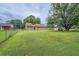 Expansive backyard featuring a well-maintained lawn, mature trees, and a charming home exterior with a sliding glass door at 1739 Brandy Woods Se Trl, Conyers, GA 30013