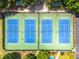 Overhead shot of a community tennis court showcasing the playing surfaces and surrounding green space at 570 Hunt River Way, Suwanee, GA 30024