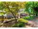 Lush backyard featuring mature trees, landscaping, and a covered patio for ultimate outdoor living at 570 Hunt River Way, Suwanee, GA 30024