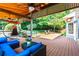 Cozy backyard features a covered deck, seating area, hammock chair, and a waterfall pond at 570 Hunt River Way, Suwanee, GA 30024