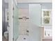 Well-lit bathroom with a tiled shower, glass door, and soaking tub near a window, showing a clean, modern design at 570 Hunt River Way, Suwanee, GA 30024