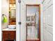 Hall bathroom features a vessel sink, custom mirror, and mixed material accent wall at 570 Hunt River Way, Suwanee, GA 30024