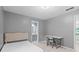 Cozy bedroom with neutral gray walls features a small desk area and a door leading to an en suite bathroom at 570 Hunt River Way, Suwanee, GA 30024