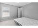 A bedroom with neutral walls features a window and a door to another room near a bed at 570 Hunt River Way, Suwanee, GA 30024