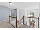 Upstairs landing overlooking foyer has wood and white spindle banister, and chandelier at 570 Hunt River Way, Suwanee, GA 30024