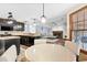 Open kitchen with stainless appliances adjacent to a living room with fireplace and dining area at 570 Hunt River Way, Suwanee, GA 30024