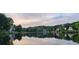 Scenic lake view featuring waterfront homes and lush greenery reflecting on the calm water at 570 Hunt River Way, Suwanee, GA 30024