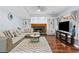 Inviting living room features a stone fireplace, hardwood floors and cozy seating at 570 Hunt River Way, Suwanee, GA 30024