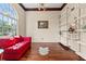 Bright living room with large windows, hardwood floors, stylish shelves, and a red sofa at 570 Hunt River Way, Suwanee, GA 30024