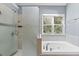 Main bath features a garden tub beneath a window and a glass enclosed shower at 570 Hunt River Way, Suwanee, GA 30024