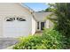 A cute green front door is flanked by lush green landscaping and an extra long driveway at 2806 Vintage Wood Nw Way, Kennesaw, GA 30144
