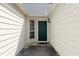 Covered front entrance featuring a green door, neutral siding, and a side window providing natural light at 2806 Vintage Wood Nw Way, Kennesaw, GA 30144