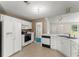 The kitchen features white cabinets and appliances, with great natural light and an open layout at 2806 Vintage Wood Nw Way, Kennesaw, GA 30144