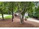 Rear exterior view with mature trees, tiered landscaping and driveway at 3009 Gant Quarters Dr, Marietta, GA 30068