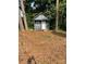 Small outdoor building with a gable roof nestled among mature trees in backyard at 354 Dublin Way, Lawrenceville, GA 30044