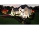 Stunning brick home showcasing manicured landscaping with vibrant flowerbeds and warm exterior lighting at 3680 Tanglewood Se Dr, Atlanta, GA 30339