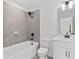 Modern bathroom with tub shower, grey tiling, and white vanity at 586 Avondale Park Cir, Decatur, GA 30032