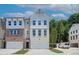 Charming townhouse with a brick and white facade, featuring a two-car garage and well-maintained landscaping at 586 Avondale Park Cir, Decatur, GA 30032