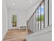 Bright foyer with wood floors, coat rack and shoe storage, and a staircase with black metal balusters at 586 Avondale Park Cir, Decatur, GA 30032