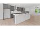 Bright kitchen with a white center island, gray cabinets, modern appliances, and a view to the living room at 586 Avondale Park Cir, Decatur, GA 30032