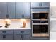Close-up of the built-in stainless oven and microwave, complemented by stylish gray cabinetry at 586 Avondale Park Cir, Decatur, GA 30032