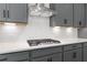 Close-up of a modern kitchen with gray cabinets, stainless steel range, and quartz countertops for a luxurious touch at 586 Avondale Park Cir, Decatur, GA 30032