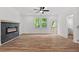 A bright living room featuring a modern electric fireplace, wood flooring, and natural light from backyard access at 586 Avondale Park Cir, Decatur, GA 30032