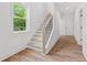 Bright staircase featuring hardwood floors and black iron railings alongside a window bringing natural light at 586 Avondale Park Cir, Decatur, GA 30032