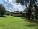 Backyard view of a brick home with a screened-in porch, yard, and mature trees at 1046 Waterside Se Dr, Conyers, GA 30013