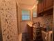 Traditional bathroom featuring floral wallpaper, wooden vanity, and natural light from the window at 1046 Waterside Se Dr, Conyers, GA 30013