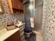 Bathroom with a shower, toilet, and vanity, decorated with floral wallpaper at 1046 Waterside Se Dr, Conyers, GA 30013